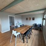Dining area with wooden table and chairs, hardwood floor, and wall art.