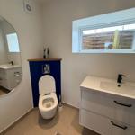 Bathroom with toilet, sink, and window