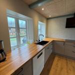 Kitchen with wooden surfaces, windows, and sink