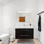 Badezimmer mit Toilette, Waschbecken und Spiegel