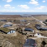 Häuser auf Dünen mit Blick aufs Meer