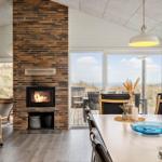 Essbereich mit Kamin und Blick auf Dünen.