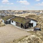 Moderne Villa mit Grasdach und Terrasse auf Dünenlage.