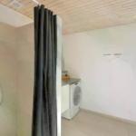 Dusche mit Duschbrause, Waschmaschine und Fenster.