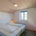 Schlafzimmer mit Doppelbett, Holzdecke und Fenster.