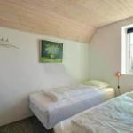Zwei Betten, Fenster, Wandbild und Holzdecke im Schlafzimmer.