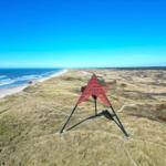 Roter Stern auf Dünen mit Blick auf Strand und Meer.