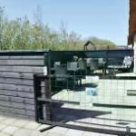 Hundegitter und Terrasse mit Tisch, Stühlen und Liege