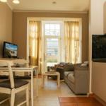 Wohnung mit Essbereich, Küche und Wohnzimmer mit Blick auf Balkon.