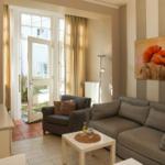 Wohnzimmer mit Sofa, Sessel und TV. Durchgang zur Terrasse mit Blick nach draußen.