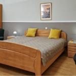 Schlafzimmer mit Holzbett, Nachttischen und Kleiderschrank.