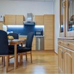 Küche mit Essbereich, Holzmöbel und Edelstahlgeräten.