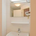 Badezimmer mit Waschbecken, Spiegel und Licht