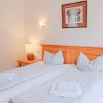 Ein Schlafzimmer mit Bett, Nachttisch und Wandlampen.