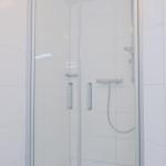 Duschbereich mit Glaswand und Duschkopf