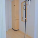 Flur mit Kleiderständer, Spiegel und Schrank.