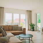 Wohnzimmer mit Sofa, Tisch und Blick auf Garten