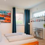 Schlafzimmer mit Bett, Kleiderschrank und Fenster mit Blick.