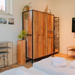 Schlafzimmer mit Bett, Kleiderschrank und Fernseher.