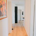 Flur mit Holzboden, Wandbild und Türen zu verschiedenen Räumen.