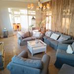 Wohnzimmer mit Holzwand, Sofa, Sessel und Couchtisch.