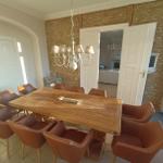 Esszimmer mit Holztisch, braunen Stühlen und Steinwand.