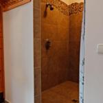 Dusche mit Steinverkleidung und Duschbrause