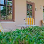 Terrasse mit Tisch und Stühlen mit gelb-weißen Kissen