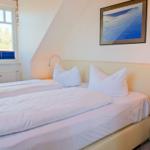 Schlafzimmer mit Doppelbett, Fenster und Nachttisch mit Lampe.