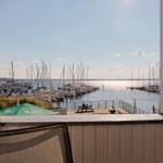 Blick vom Balkon auf Hafen mit Booten und Sonnenschein.