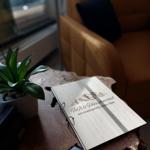 Holztablett mit Informationsbuch und Pflanze im Wohnbereich