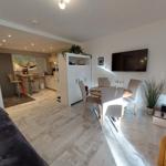 Wohnbereich mit Essplatz, Fernseher und Blick in die Küche.