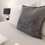 Bettkopfteil mit Kissen und dekorativer Kissen mit Aufschrift.