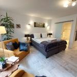 Schlafzimmer mit Bett, Sofa und Blick in die Dusche