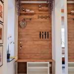 Eingangsbereich mit Holzwand, Haken und Sitzbank. Dekoration mit Herz und Blumen.