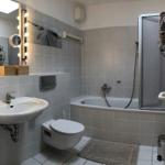 Badezimmer mit Badewanne, Dusche, Waschbecken und Toilette.