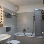 Badezimmer mit Badewanne, Dusche, Waschbecken und Toilette. Dachfenster sorgt für Tageslicht.