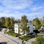 Weißes Haus mit Garten, Parkplatz und Blick auf Riesenrad.