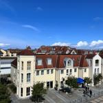 Stadtansicht mit Gebäuden, Dächern und blauem Himmel.