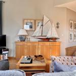 Wohnzimmer mit Holzmöbeln, Segelschiffmodell und Fernseher.