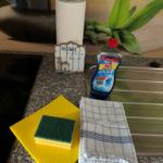 Küchenarbeitsfläche mit Reinigungsmitteln und Küchenhandtüchern.