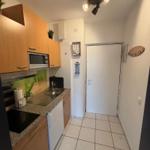 Küche mit Holzschrank, Spüle und Kochfeld.