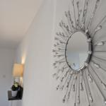 Sonnige Wanddekoration mit Spiegel und Kristallapplikationen