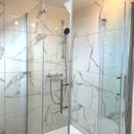 Duschkabine mit Glaswand und Marmorfliesen