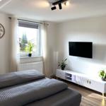 Schlafzimmer mit Bett, Fernseher und Fenster mit Blick.