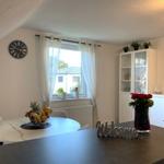 Essbereich mit runder Tisch, Fenster und weißen Schränken.