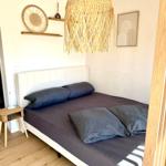 Schlafzimmer mit Bett, Stehlampe und Wanddekoration.