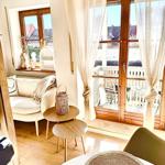 Wohnbereich mit Sitzgelegenheit, Tisch und Balkonzugang.