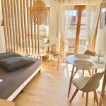 Schlafzimmer mit Bett, Essbereich und Balkonansicht.