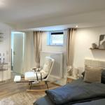 Schlafzimmer mit Bett, Schaukelstuhl und Fenster